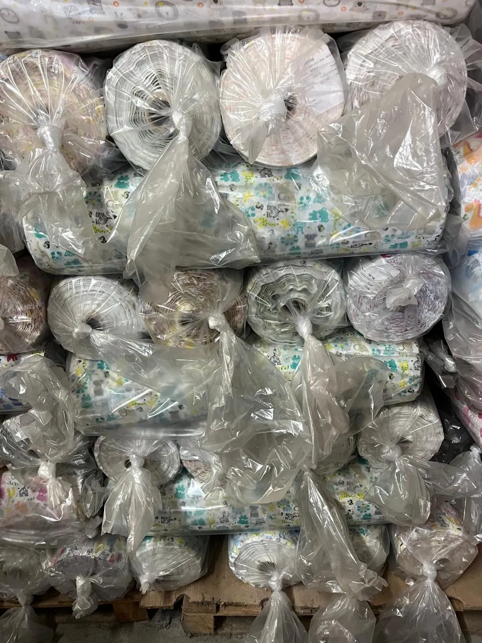 Rollos de tela envueltos y apilados en el depósito de Textil Chiletex